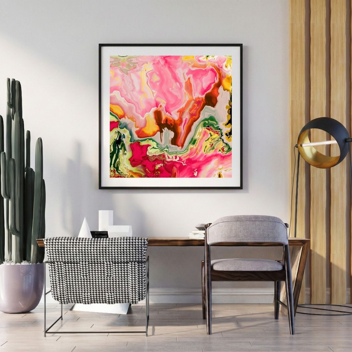 Modern interior with a colorful neon pink abstract print on the wall, a desk, and decorative items.
