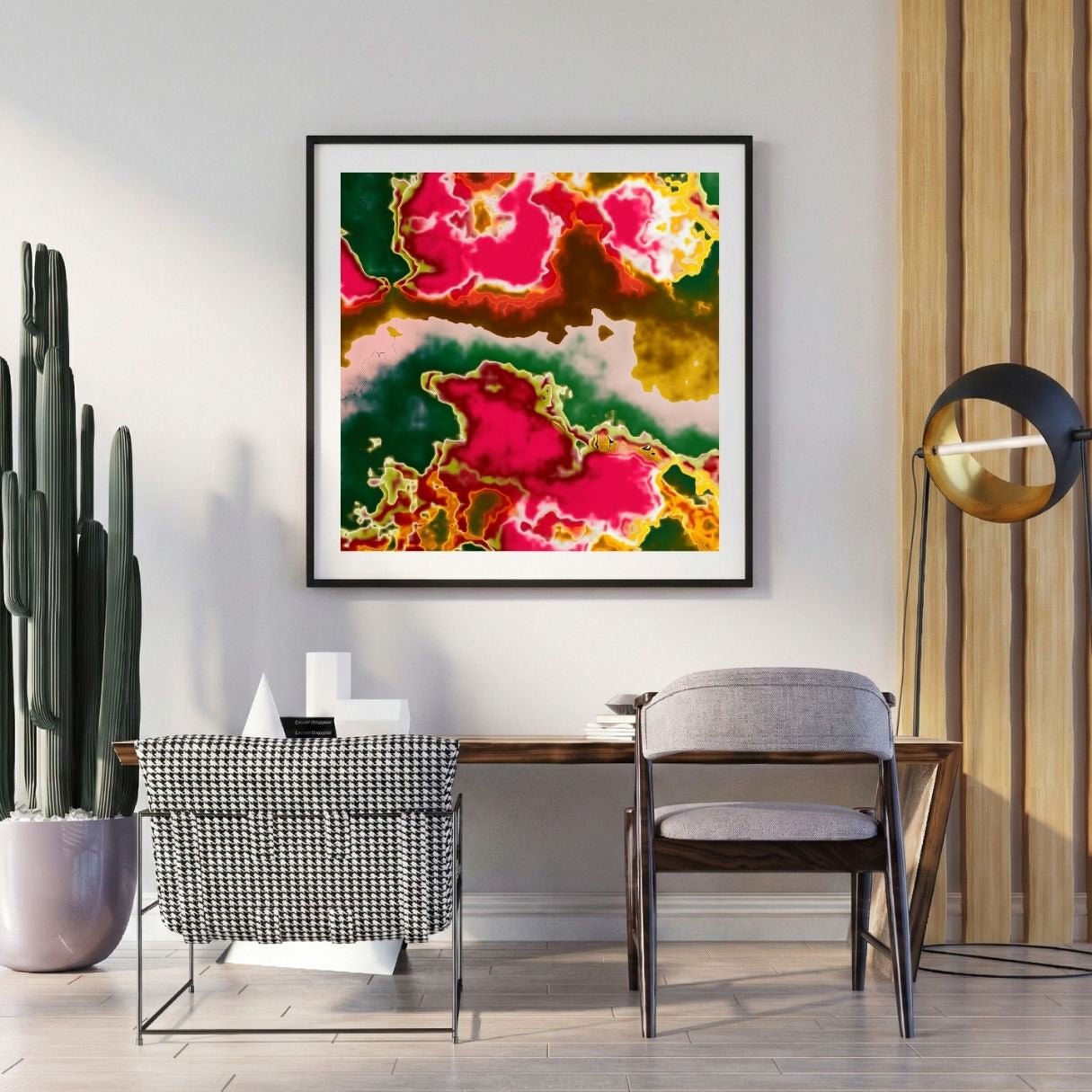 Modern interior with a colorful neon pink abstract print on the wall, a desk, and decorative items.