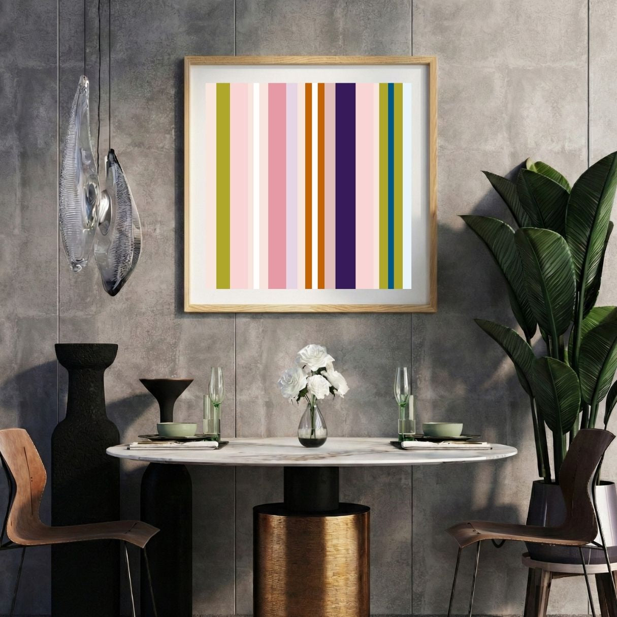 Modern interior with a pink striped print on a gray wall, marble table, and decorative items.