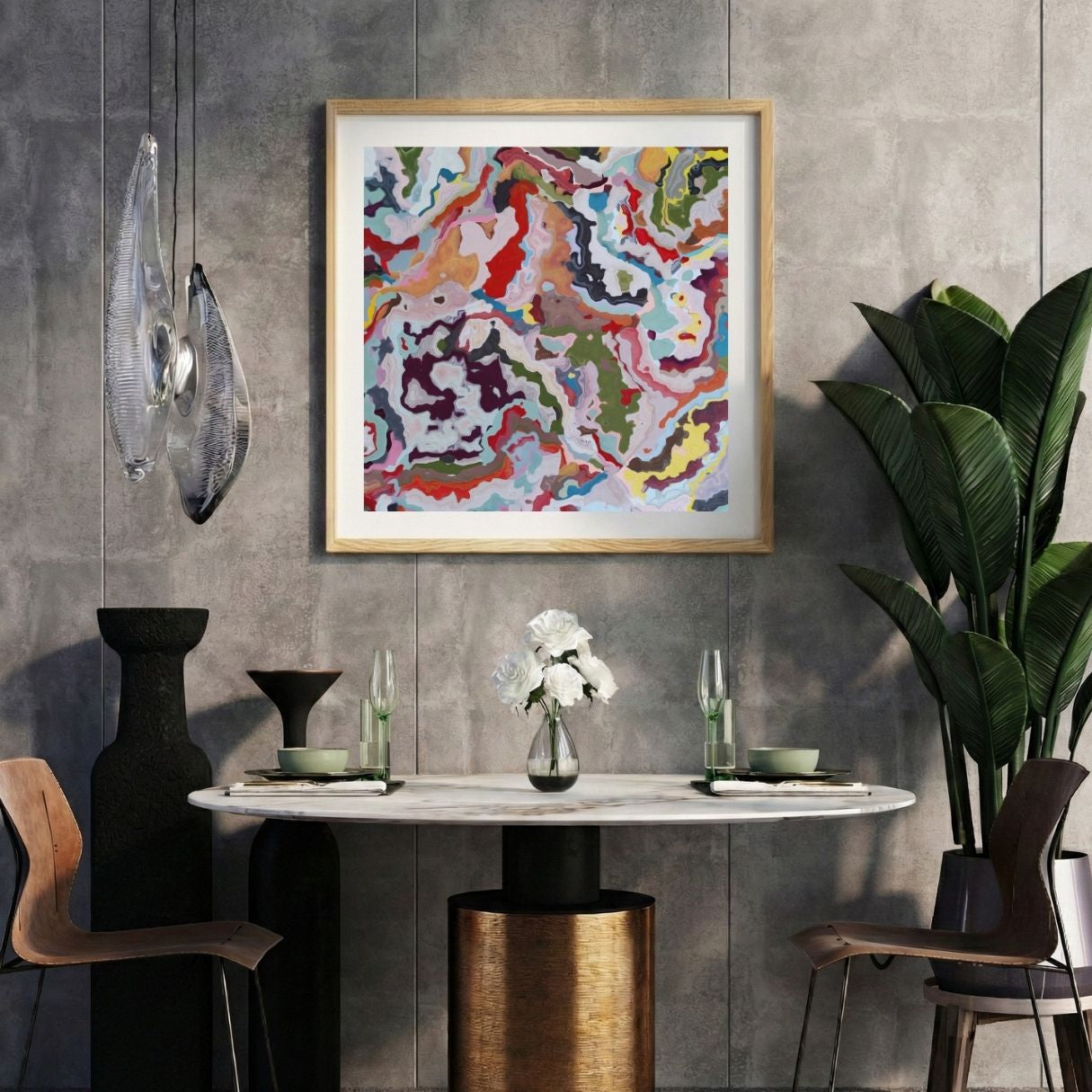 Modern interior with a marbled multicolor abstract print on a gray wall, marble table, and decorative items.
